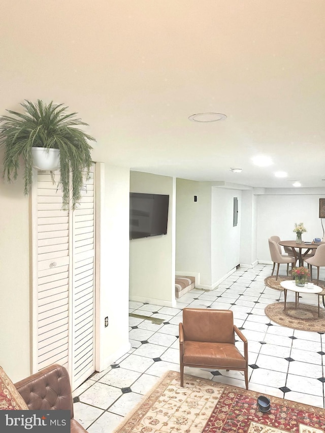 living area featuring light tile patterned flooring and baseboards