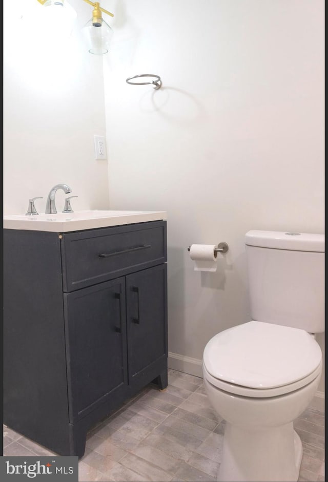 bathroom featuring vanity, toilet, and baseboards