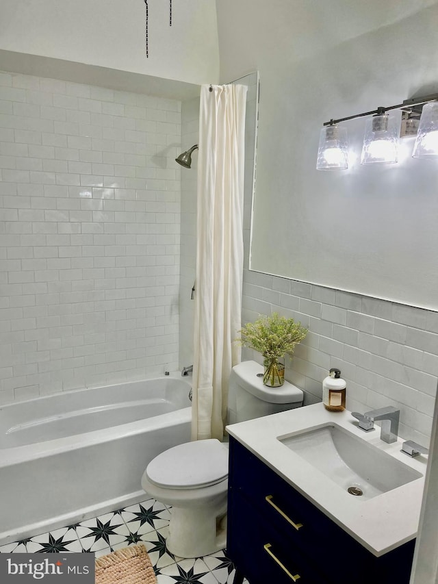 bathroom featuring vanity, tile walls, toilet, and shower / bath combo