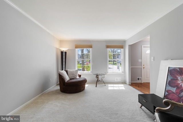 sitting room featuring ornamental molding, baseboards, carpet, and visible vents
