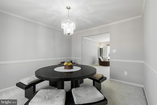 dining space with a chandelier, carpet flooring, baseboards, and ornamental molding