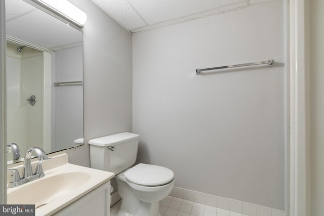 bathroom featuring tile patterned floors, vanity, walk in shower, and toilet