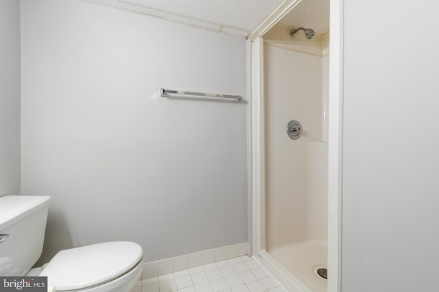 bathroom featuring tile patterned floors, toilet, and a stall shower