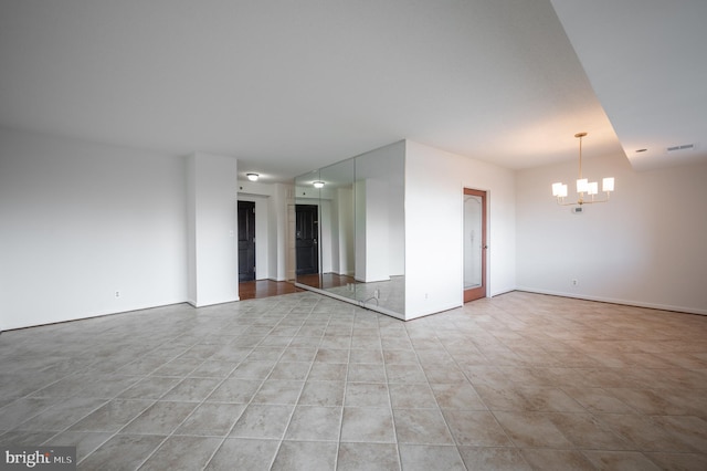 spare room featuring an inviting chandelier