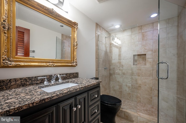 bathroom featuring vanity, an enclosed shower, and toilet