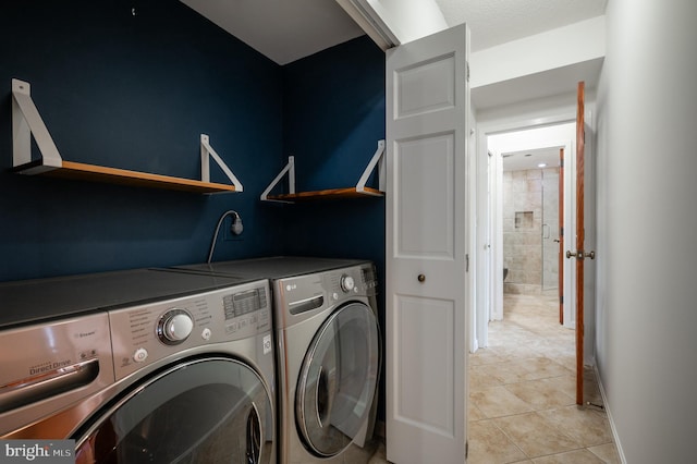 laundry area with separate washer and dryer and light tile patterned floors