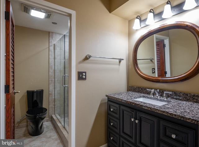 bathroom featuring a shower with door, vanity, and tile patterned flooring