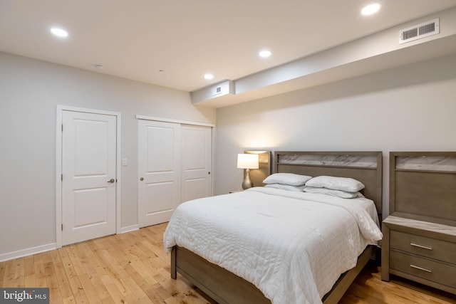 bedroom with light wood-type flooring and a closet