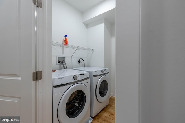 washroom with independent washer and dryer and light wood-type flooring