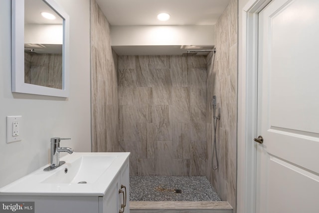 bathroom with vanity and a tile shower