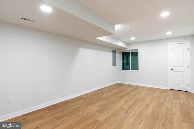 basement featuring electric panel and light wood-type flooring