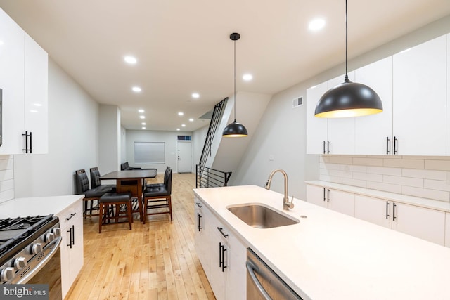 kitchen featuring pendant lighting, white cabinetry, and sink