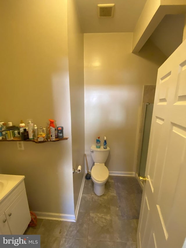 bathroom featuring walk in shower, vanity, and toilet