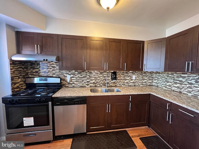 kitchen with sink, stainless steel appliances, tasteful backsplash, light hardwood / wood-style floors, and light stone countertops