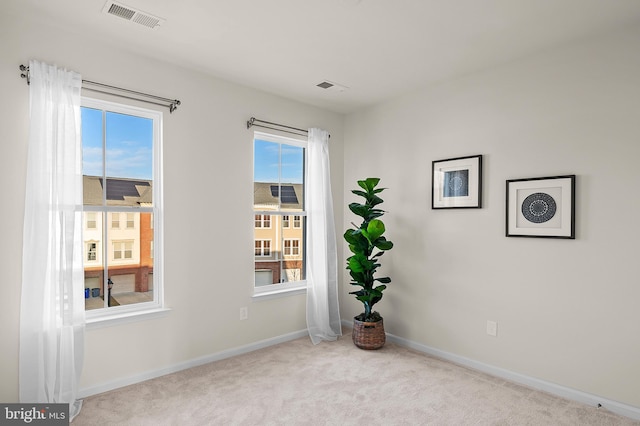 unfurnished room with a wealth of natural light and light carpet