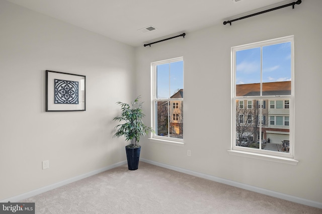 carpeted empty room featuring plenty of natural light