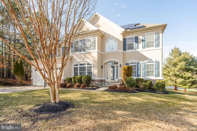 view of front of house with a garage, a front lawn, and solar panels