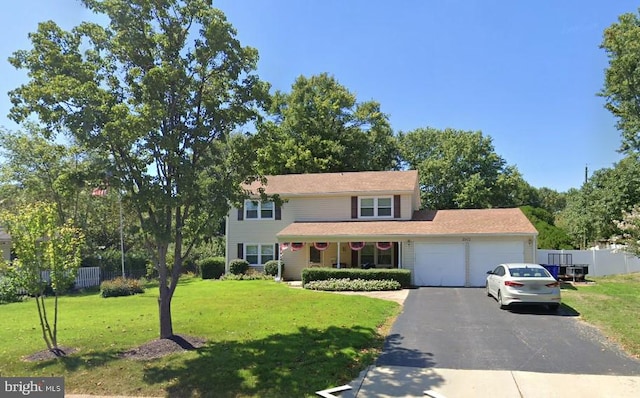 view of front of house featuring a garage, a front lawn, and covered porch