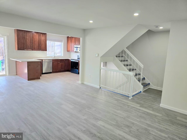 kitchen with backsplash, light wood-type flooring, sink, and appliances with stainless steel finishes