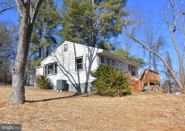 view of side of property with central AC and a wooden deck