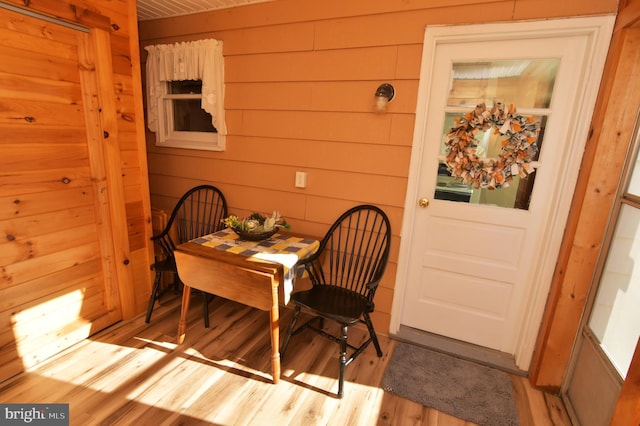 dining area with light wood finished floors and wooden walls