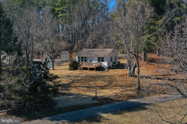 view of front facade with a storage unit, an outdoor structure, and a wooden deck