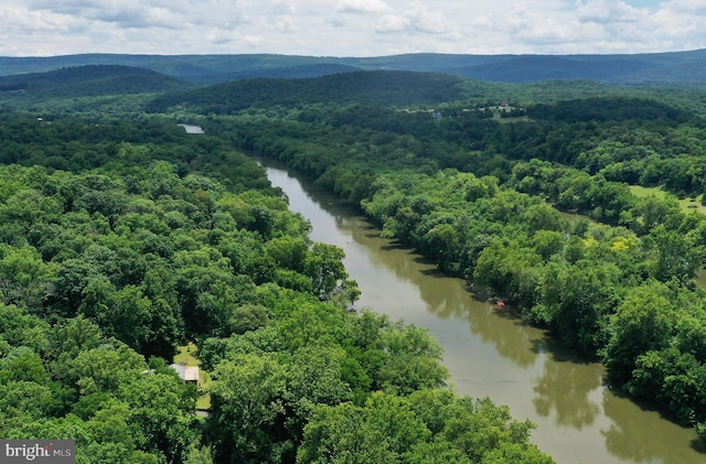 drone / aerial view with a water and mountain view and a view of trees