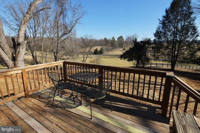 deck featuring outdoor dining space and a rural view