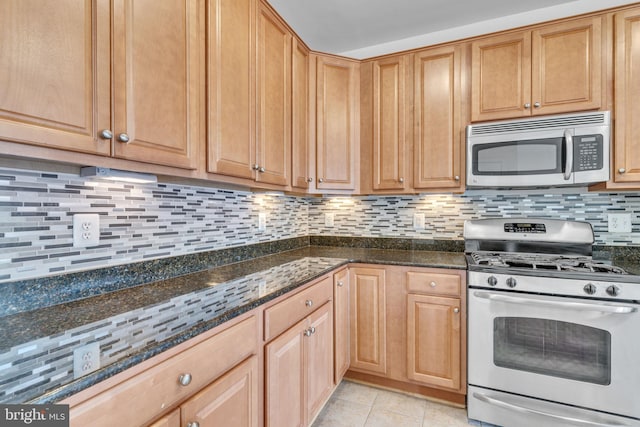 kitchen featuring dark stone counters, light tile patterned floors, tasteful backsplash, and stainless steel appliances