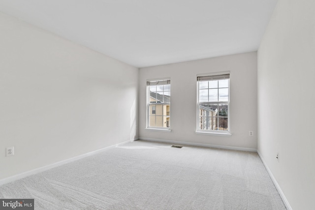 spare room with visible vents, baseboards, and carpet flooring