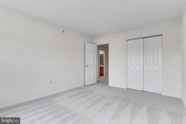 unfurnished bedroom with a closet, baseboards, and carpet floors