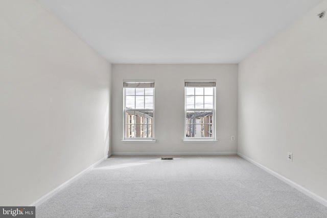 spare room featuring visible vents, baseboards, and carpet