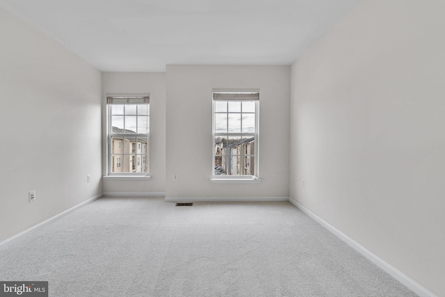 unfurnished room with visible vents, baseboards, and carpet