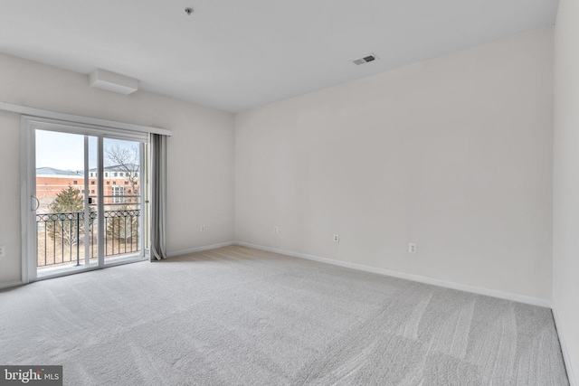 spare room with baseboards, carpet floors, and visible vents