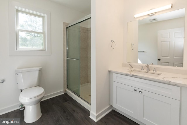 bathroom with wood finished floors, a stall shower, baseboards, and toilet