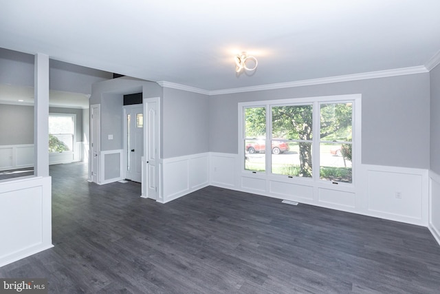 spare room featuring ornamental molding, dark wood-style flooring, a wainscoted wall, and a decorative wall