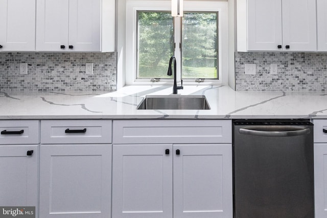 kitchen with dishwasher, a sink, white cabinets, and backsplash