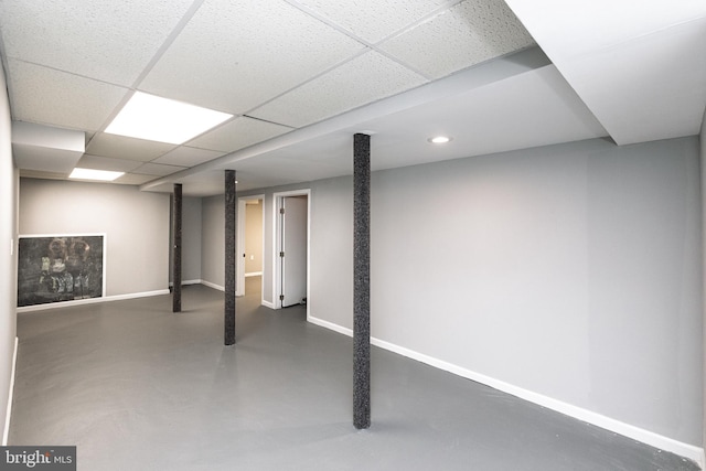 finished below grade area featuring baseboards, a paneled ceiling, and recessed lighting