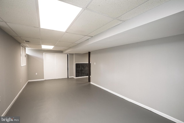 finished below grade area with a paneled ceiling and baseboards