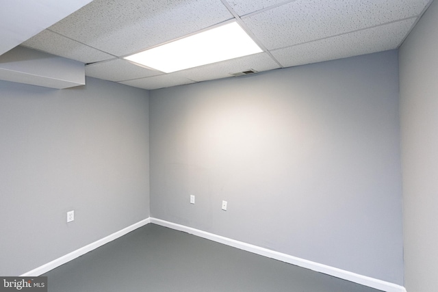 unfurnished room with a drop ceiling and baseboards