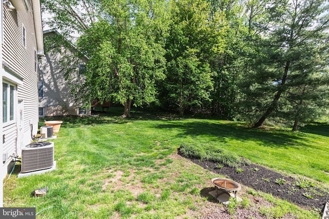 view of grassy yard featuring central AC