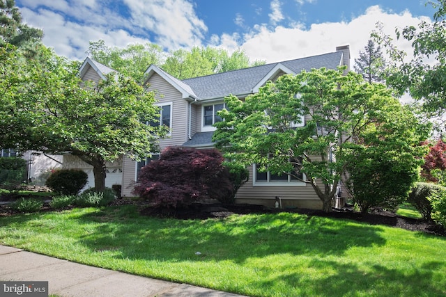 obstructed view of property with a front lawn and roof with shingles