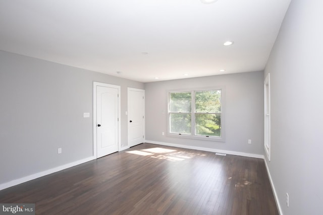 spare room with baseboards, dark wood-style floors, and recessed lighting