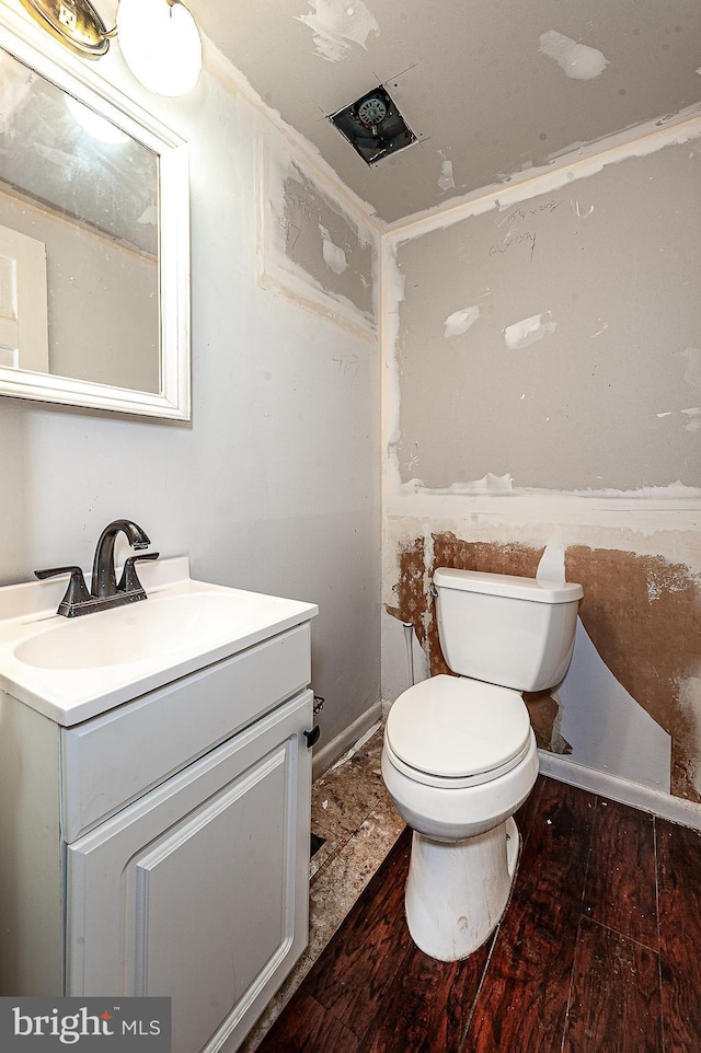 bathroom with vanity, wood-type flooring, and toilet