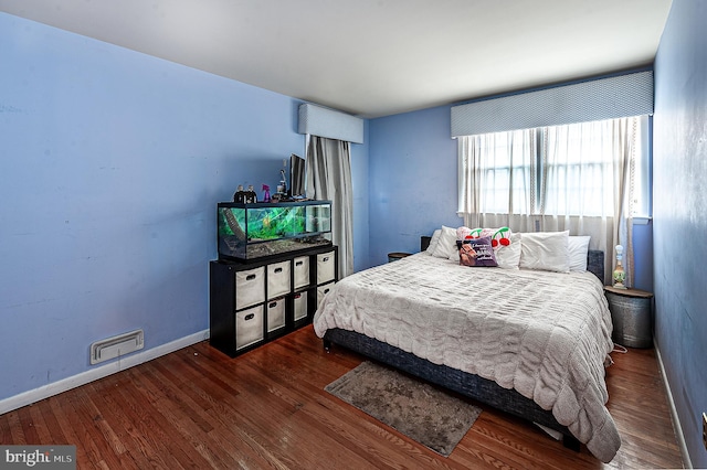 bedroom with dark wood-type flooring