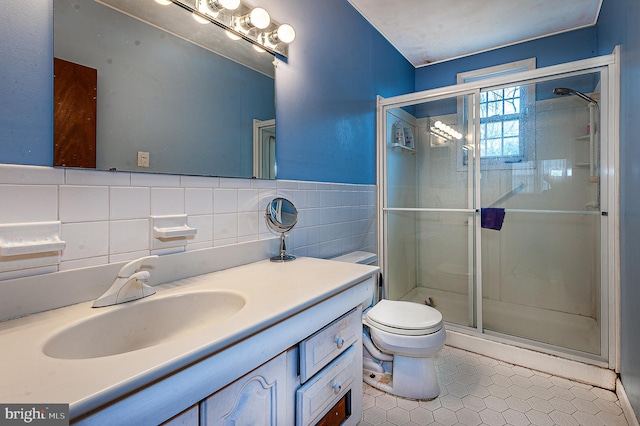 bathroom with vanity, toilet, tile walls, and a shower with shower door