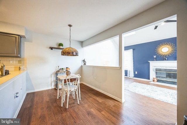 dining room featuring a premium fireplace and dark wood-type flooring