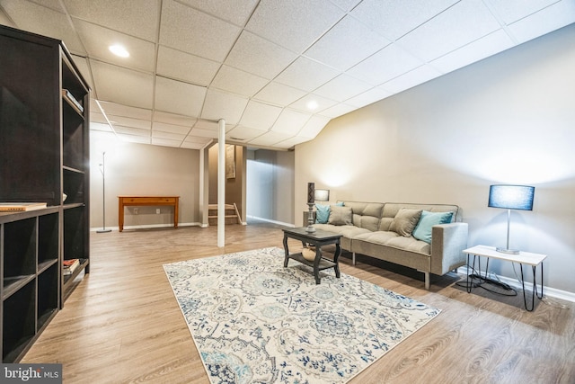 living room featuring a drop ceiling and hardwood / wood-style floors