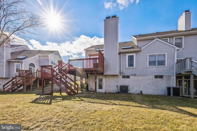 back of property with central AC, a yard, and a deck