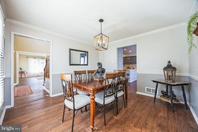 dining area featuring ornamental molding, dark hardwood / wood-style floors, and a notable chandelier